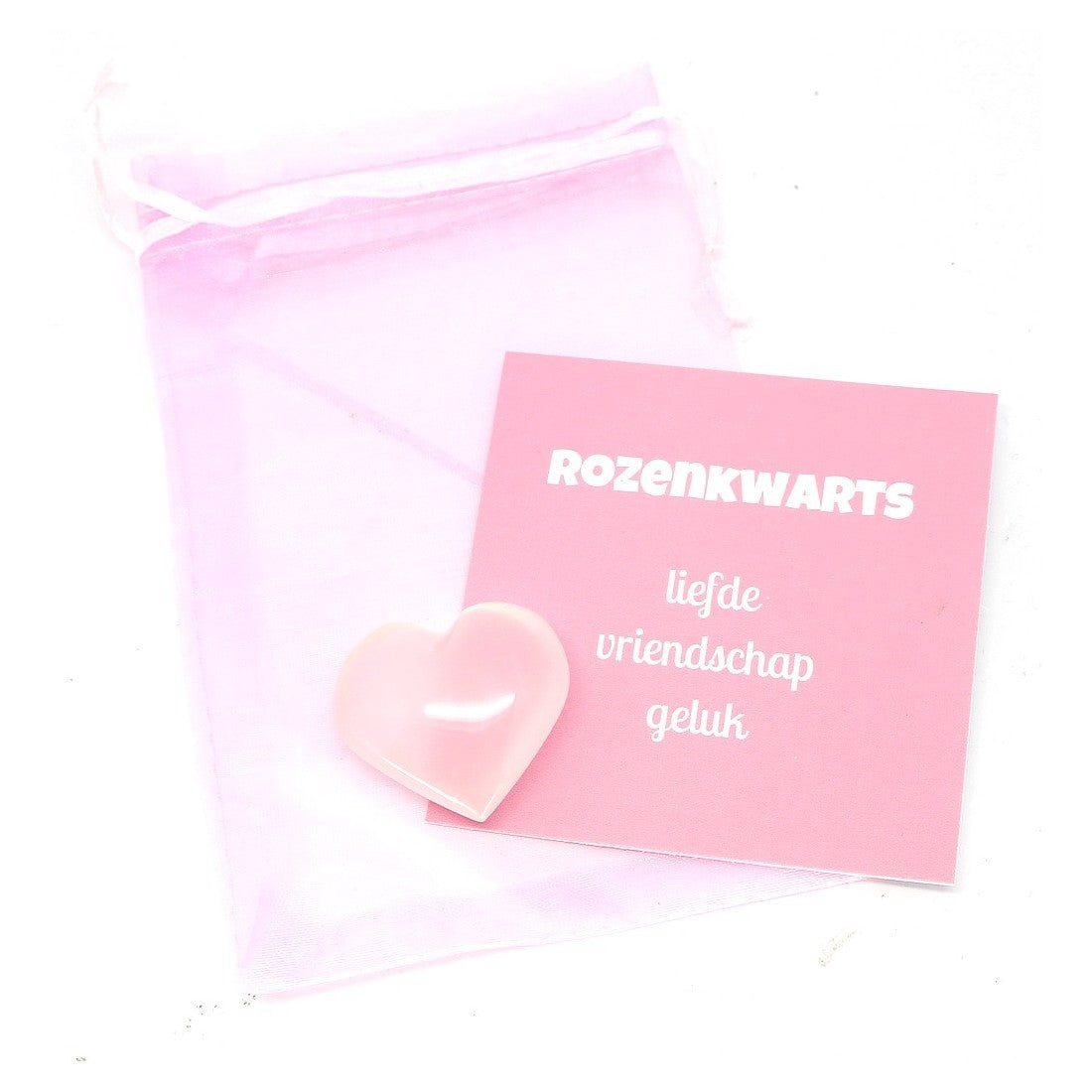 Hartje van rozenkwarts edelsteen in een bewaarzakje met uitleg